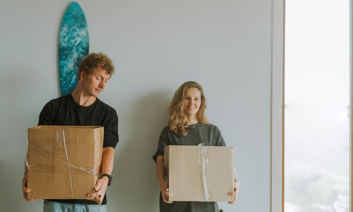 Dog standing with owners and moving boxes while adjusting to a new home