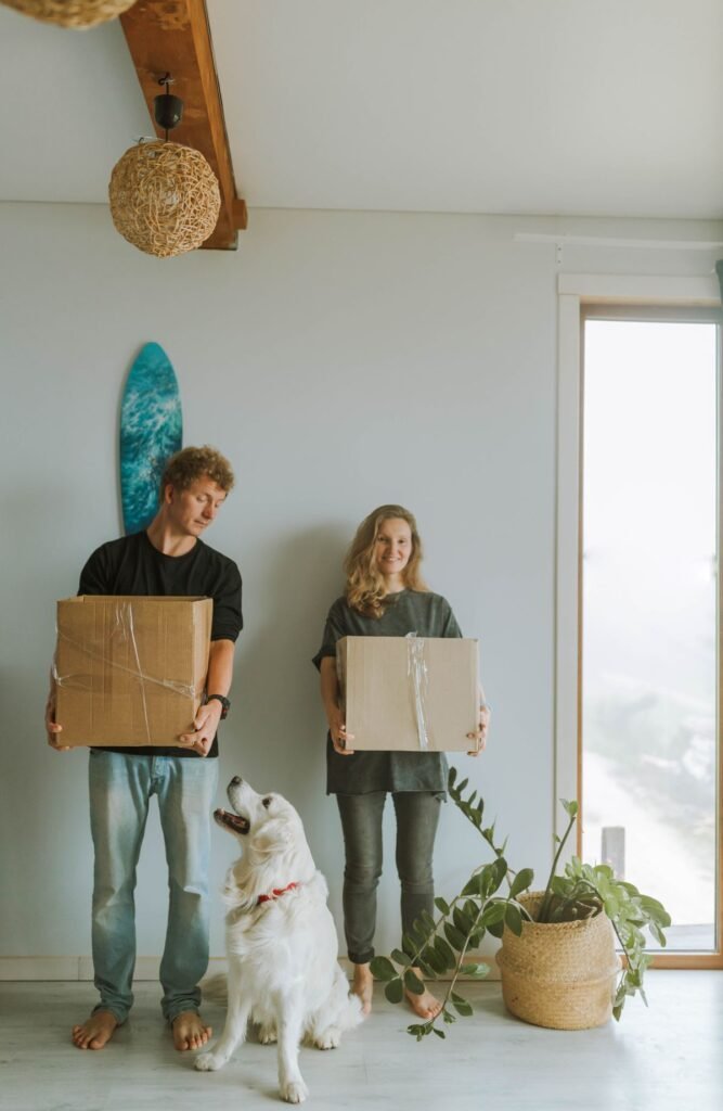 Dog standing with owners and moving boxes while adjusting to a new home