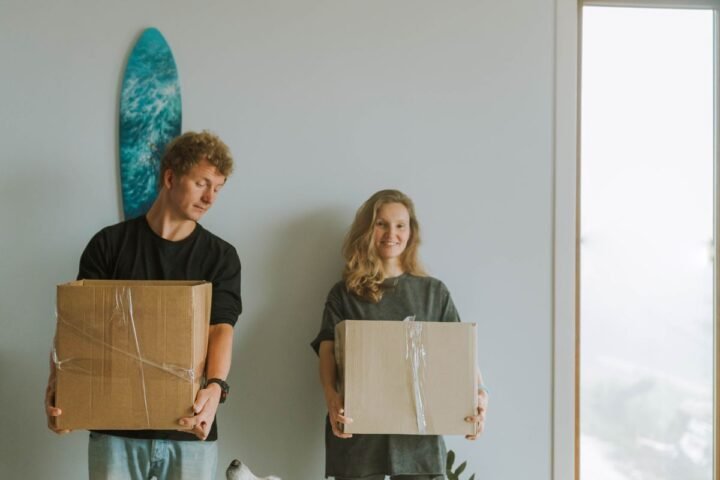 Dog standing with owners and moving boxes while adjusting to a new home